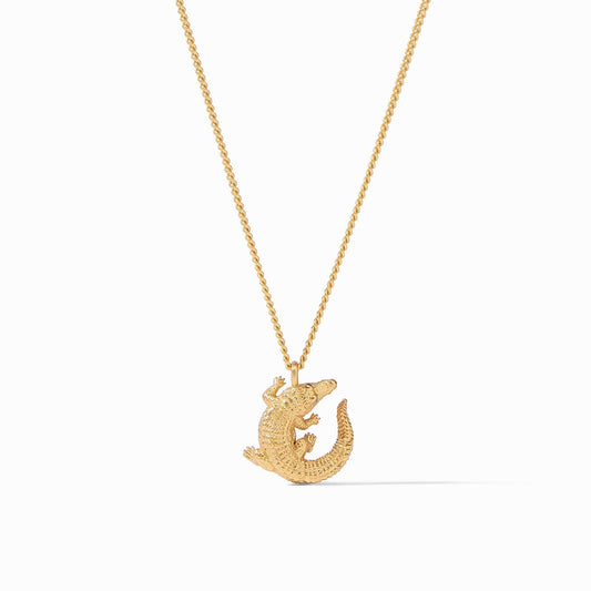 A miniature golden alligator with glittering CZ eyes suspended beneath a delicate curb chain.